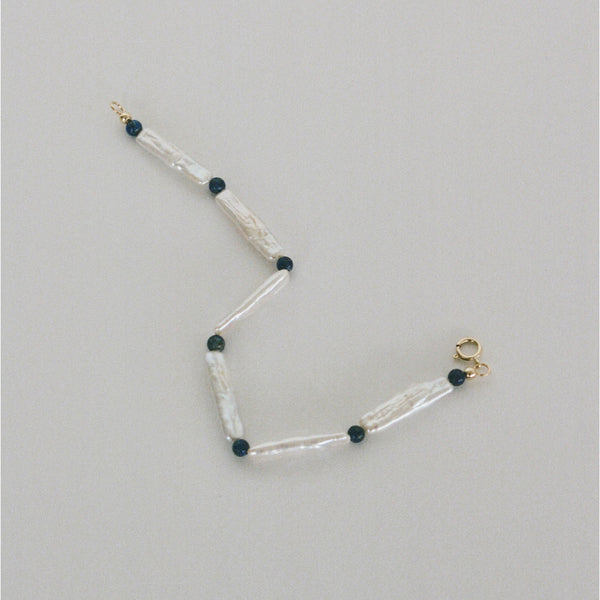 Pearl bracelet handmade in London, UK, with freshwater pearls, lapis lazuli beads and 9k gold spring ring clasp. Made using ethical and sustainable processes.