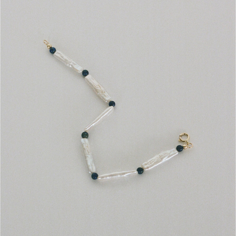 Pearl bracelet handmade in London, UK, with freshwater pearls, lapis lazuli beads and 9k gold spring ring clasp. Made using ethical and sustainable processes.