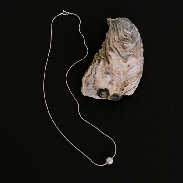 Pearl and delicate silver necklace handmade in London, UK. Made using ethical and sustainable processes with round freshwater pearl and silver snake chain.